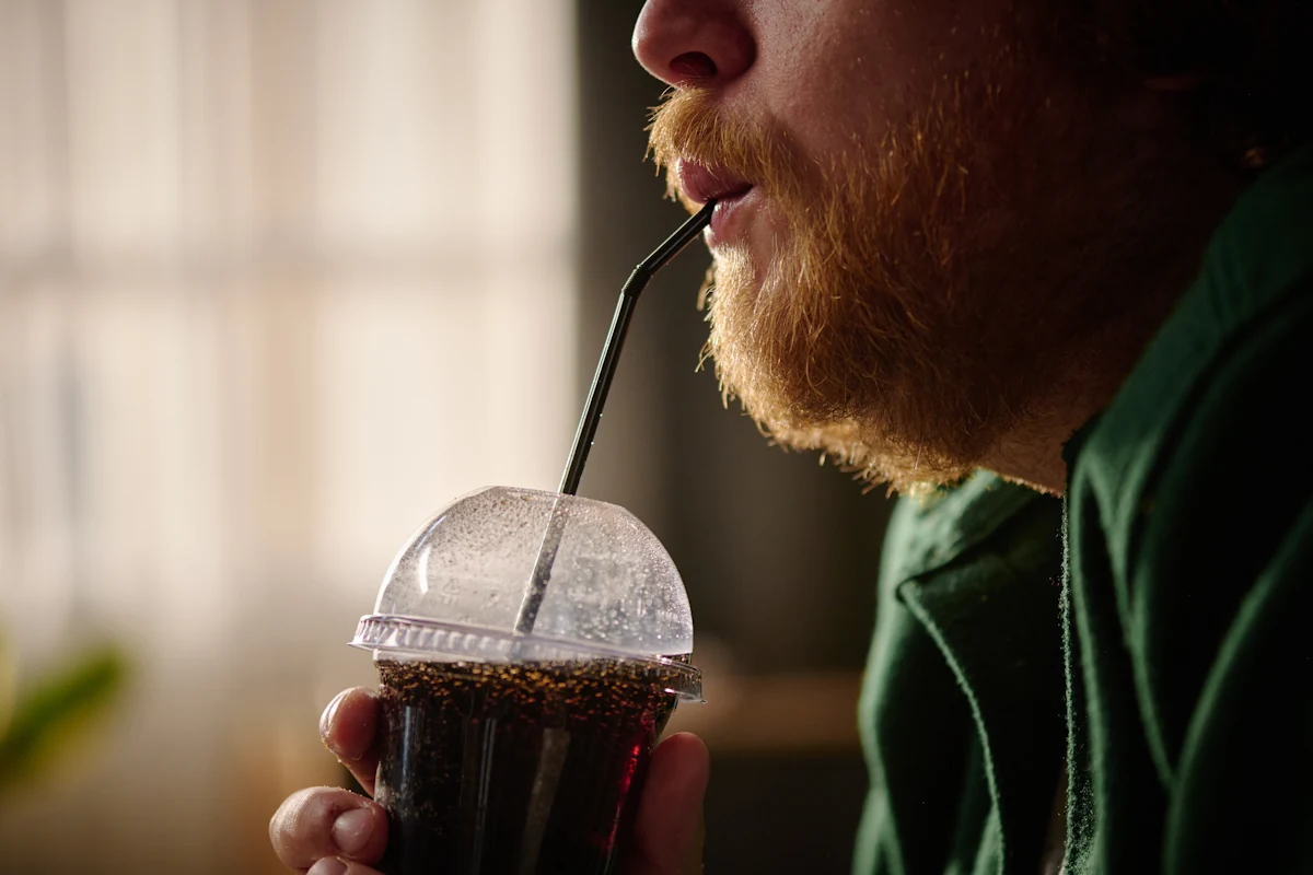 Un homme qui boit du soda